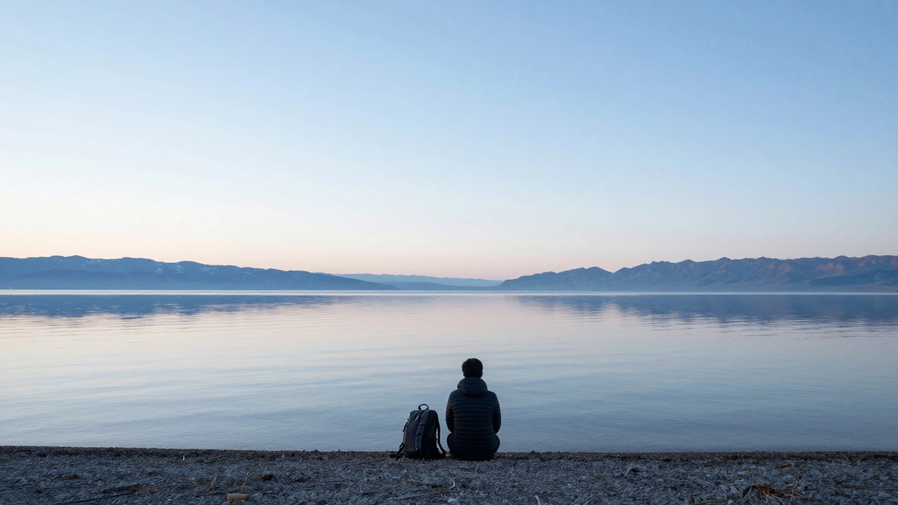 Человек у озера Байкал, спокойный пейзаж и горы на горизонте